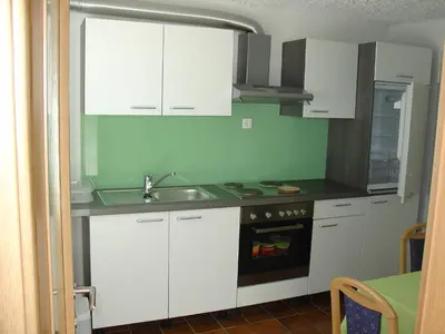 a kitchen with white cabinets and a sink at Apartment Zadraga in Tolmin