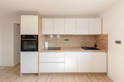 a kitchen with white cabinets and a sink at Yellow and Green apartments in Ljubljana