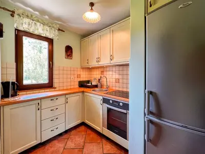 a kitchen with white cabinets and a stainless steel refrigerator at Casa Kolpa in Dragatuš