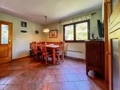 a dining room with a table and chairs and a window at Casa Kolpa in Dragatuš