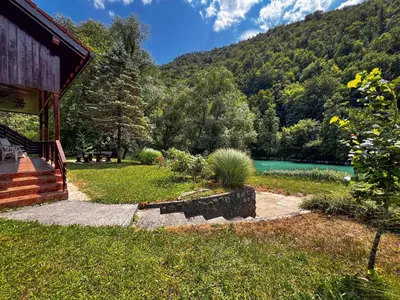 a cabin with a view of a lake and mountains at Casa Kolpa in Dragatuš