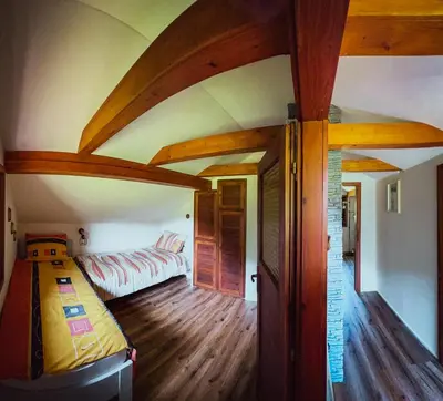 a bedroom with a bed in a room with wooden floors at Casa Kolpa in Dragatuš