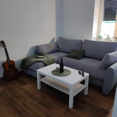 a living room with a blue couch and a white coffee table at Elegant City Escape Old Town Ptuj Apartment in Ptuj