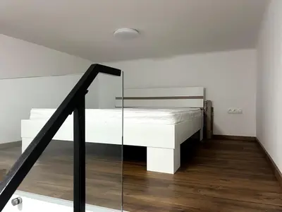 a white bed in a room with a staircase at Elegant City Escape Old Town Ptuj Apartment in Ptuj