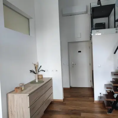 a living room with a wooden dresser and a hallway at Elegant City Escape Old Town Ptuj Apartment in Ptuj