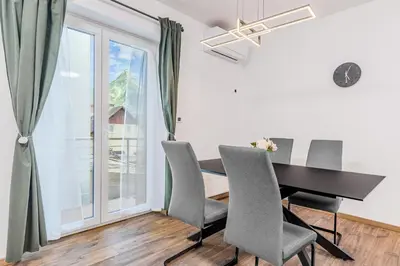 a dining room with a table and chairs and a window at Apartmaji Gašperčič, NEJC in Bovec