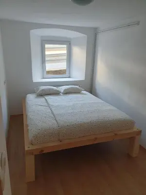 a bed in a room with a window at Apartment old house Koren in Tržič
