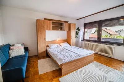 a bedroom with a bed and a blue couch at B&B Apartment Racman in Brežice