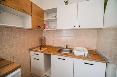 a small kitchen with white cabinets and a sink at B&B Apartment Racman in Brežice