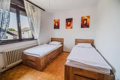 two twin beds in a room with a window at B&B Apartment Racman in Brežice