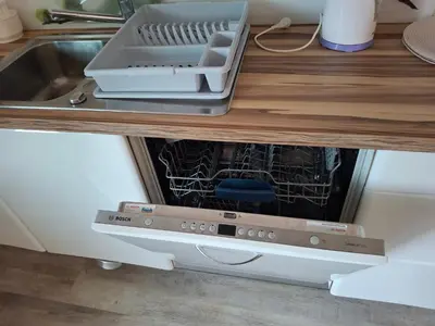 a dishwasher in a kitchen under a counter at Apartma Jasen in Ilirska Bistrica