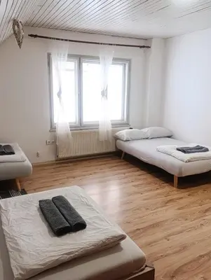a room with two beds and a large window at Apartment for families or groups in Ljubljana