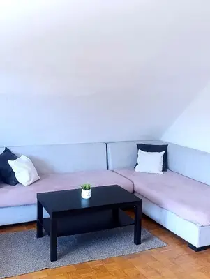 a couch with a coffee table in a living room at Apartment for families or groups in Ljubljana