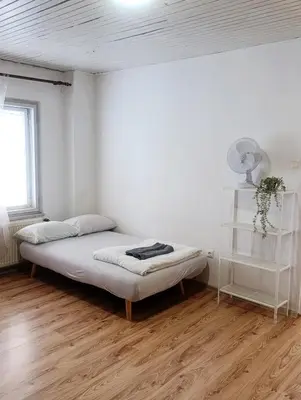 a white room with a bed and a window at Apartment for families or groups in Ljubljana