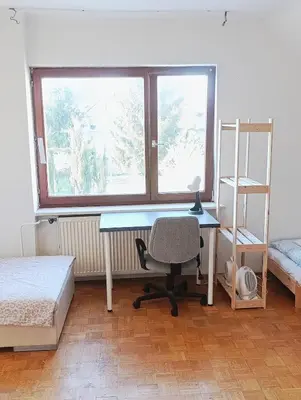 a bedroom with a desk and a chair and a window at Apartment for families or groups in Ljubljana