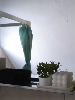 a shelf with plants and a green umbrella on it at Apartment for families or groups in Ljubljana