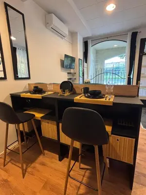 a kitchen with a large black counter with two chairs at Studio Lent Riverstay in Maribor