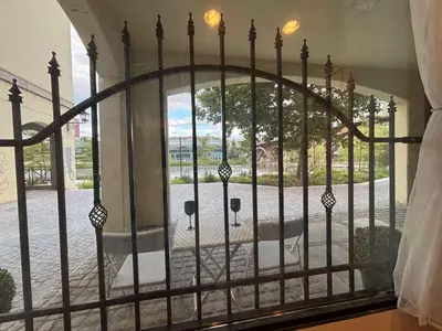 an iron gate with a view of a courtyard at Studio Lent Riverstay in Maribor
