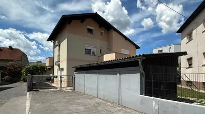 a building with a gate in front of a house at Apartments Gorishka in Ljubljana