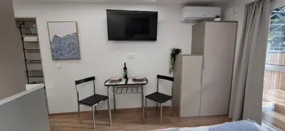 a small table and chairs in a room with a tv at Studio Suha living in Škofja Loka