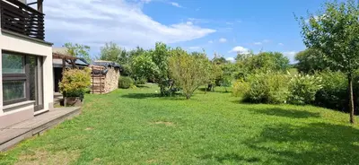 a yard with green grass and trees next to a house at Studio Suha living in Škofja Loka