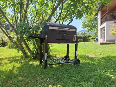 a grill sitting in the grass in a yard at Studio Suha living in Škofja Loka