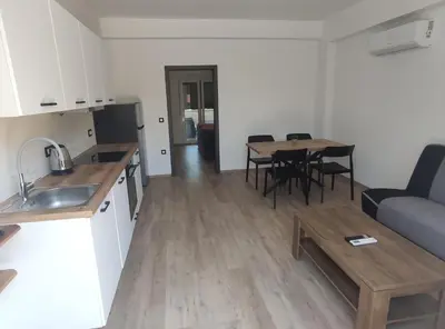 a kitchen and living room with a table and a couch at Družinski apartmaji Judnič in Adlešiči