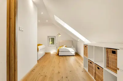 a room with two beds and a hallway with wood floors at Lux House Natura with Sauna & Hot Tub