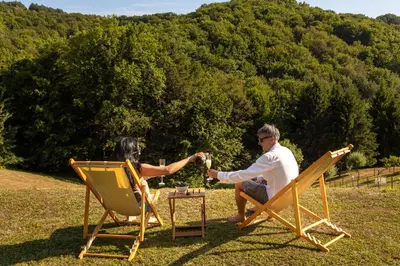 a man and a woman sitting in lawn chairs at Lux House Natura with Sauna & Hot Tub