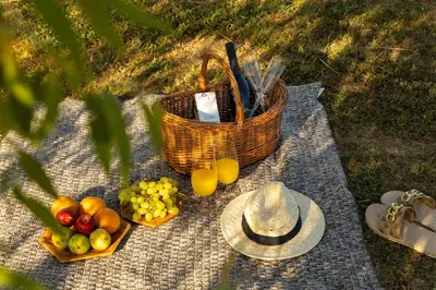 a picnic with a basket of fruit and a hat at Lux House Natura with Sauna & Hot Tub