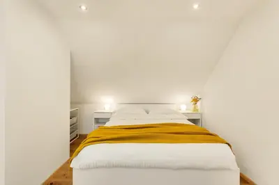 a white bedroom with a bed with a yellow blanket at Lux House Natura with Sauna & Hot Tub