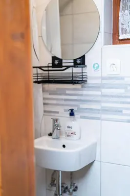 a bathroom with a sink and a mirror at Hiška Nives in Krstenica