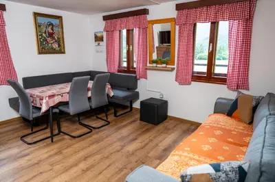 a living room with a table and chairs and a couch at Hiška Nives in Krstenica