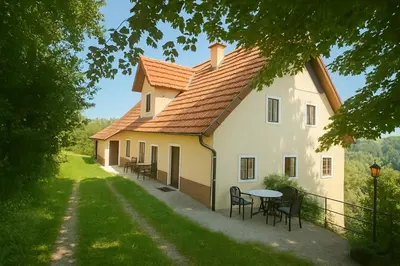 a large white house with a table and chairs at Hiša p'r Kobalu in Idrija