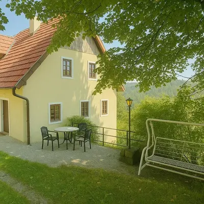 a table and chairs in front of a house at Hiša p'r Kobalu in Idrija