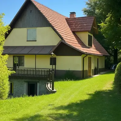 a house with a red roof on a green lawn at Hiša p'r Kobalu in Idrija