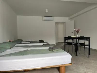 a bedroom with two beds and a table with chairs at Odisej House Tolmin in Tolmin