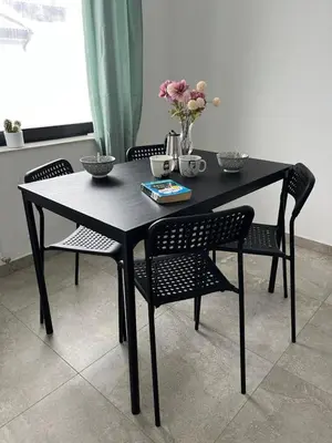 a black table and chairs with flowers on it at Odisej House Tolmin in Tolmin