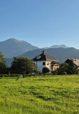 a house in a field with mountains in the background at Vila Moka near Bled-Entire place with Garden Retreat in Lesce