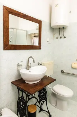 a bathroom with a sink and a toilet and a mirror at Apartment Valetovi in Štanjel