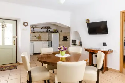 a kitchen and dining room with a table and chairs at Apartment Valetovi in Štanjel