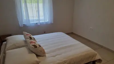 a bedroom with a white bed with a window at Apartma Danica in Kobarid