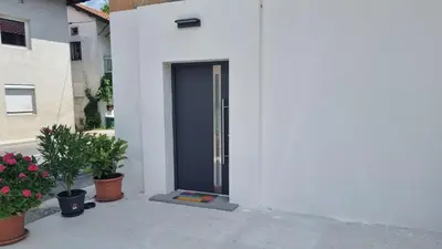 a blue door on a white building with potted plants at Apartma Danica in Kobarid