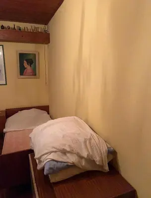 a small bedroom with a bed in a corner at Hiša p'r Kobalu- in Idrija