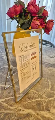 a vase filled with red roses on a table at Mega Apartmaji in Rogaška Slatina
