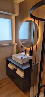 a bathroom with a sink and a mirror at Mega Apartmaji in Rogaška Slatina