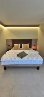 a bedroom with a large bed with a wooden headboard at Mega Apartmaji in Rogaška Slatina