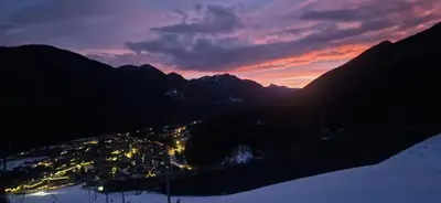 a view of a town in the mountains at sunset at Apartment Brina in Kranjska Gora