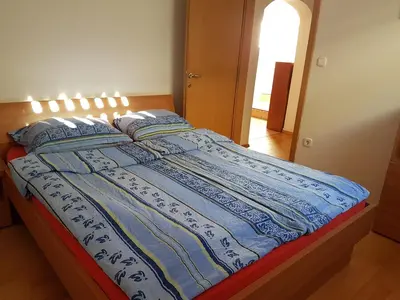 a bed with a blue and white blanket on it at Apartment Brina in Kranjska Gora