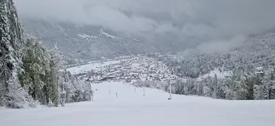 a snow covered ski slope with a town in the distance at Apartment Brina in Kranjska Gora